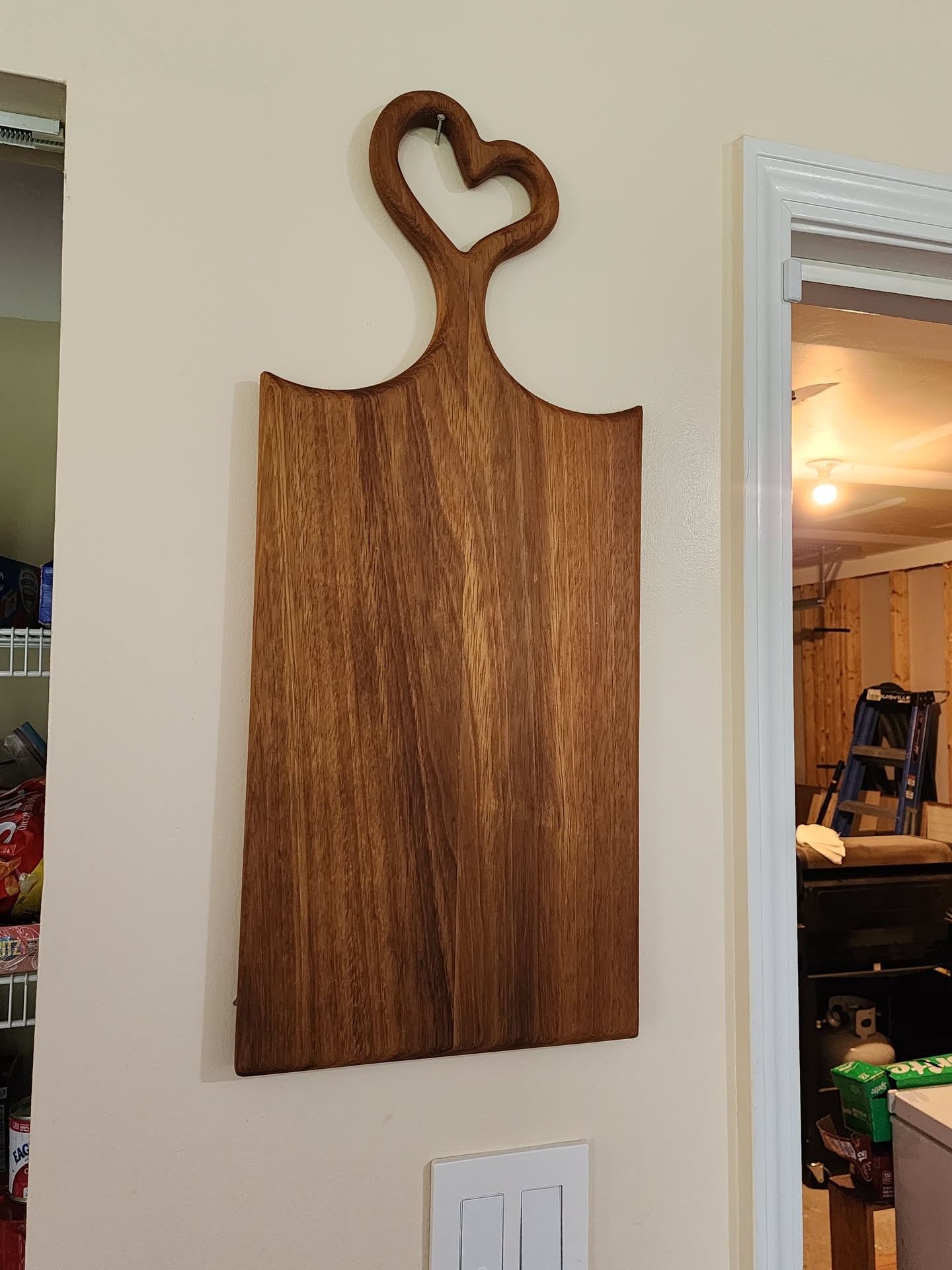 African teak charcuterie board hanging on wall